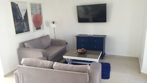 A living room with a sofa, a coffee table, a TV, and a blue cabinet.