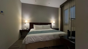 A hotel room with a bed, nightstands, lamps, a desk, and a large window with curtains. - Hotel Costa del Sol Trujillo Centro (Trujillo)
