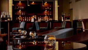 Een bar met een barman, een toog en zitplaatsen.