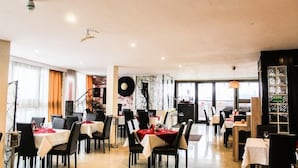 A restaurant with multiple tables, chairs, and a piano. - Razvan (Bucharest)