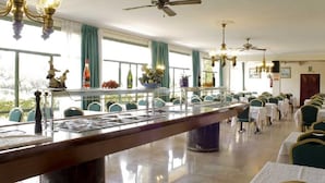 Un espace repas doté d’un long comptoir, de plusieurs chaises et de ventilateurs de plafond.