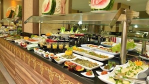 A buffet with various dishes and a decorative watermelon centerpiece. - Asrin Beach (Alanya)