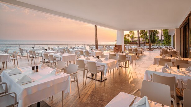 A restaurant with tables and chairs arranged on a terrace overlooking the ocean. - Yalihan Aspendos Hotel (Alanya)