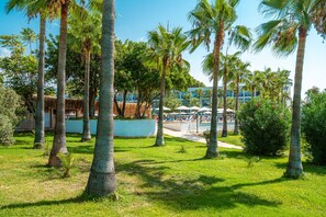 A resort with palm trees, a pool area, and a building with a blue facade. - Yalihan Aspendos Hotel (Alanya)