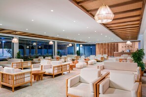 A spacious indoor area with multiple seating arrangements, a reception desk, and large windows. - Yalihan Aspendos Hotel (Alanya)