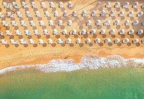 An aerial view of a beach with rows of white umbrellas and lounge chairs. - Yalihan Aspendos Hotel (Alanya)