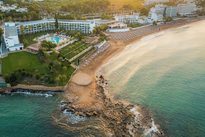 An aerial view of a coastal hotel with a swimming pool, beach, and rocky shoreline. - Yalihan Aspendos Hotel (Alanya)