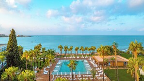A resort with a pool, palm trees, and a view of the sea. - Yalihan Aspendos Hotel (Alanya)