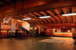 A wooden interior with a reception desk labeled "SPÖRTHAUS HOTEL" and a staircase leading to an upper level. - Sport Hotel (Soldeu)