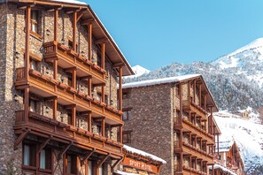 A multi-story hotel with wooden balconies and a sign reading "Sport Hotel". - Sport Hotel (Soldeu)