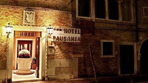 A historic building with a sign reading "HOTEL PAUSANIA." It features arched windows and a balcony. - Pausania Hotel (Venice)