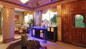 Una zona de bar con un cantinero, un jarrón decorativo y un techo con diseño.