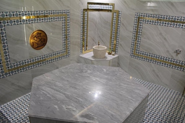 A bathroom with a large marble sink, a gold decorative plate, and patterned tile walls. - Adriatik Hotel, BW Premier Collection (Durrës)
