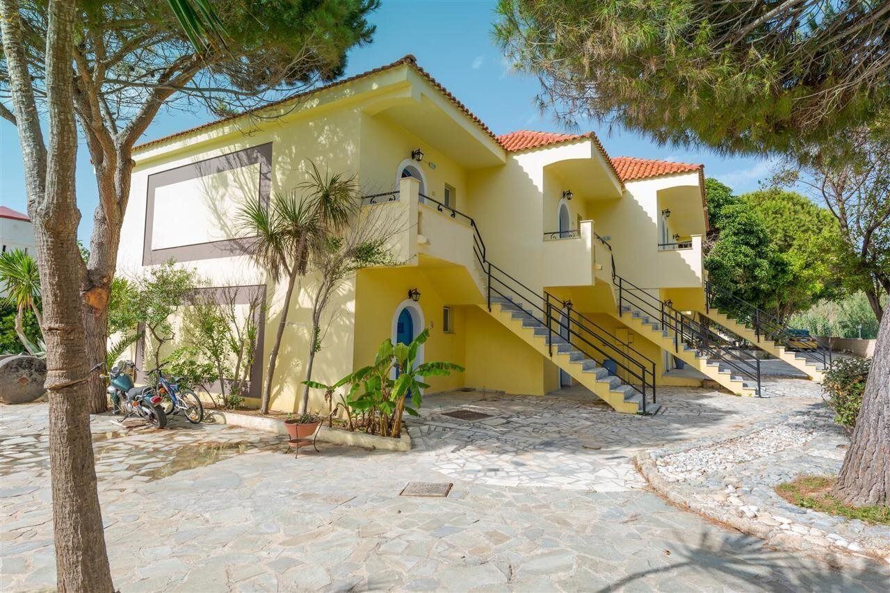 A yellow building with a staircase and a small balcony.