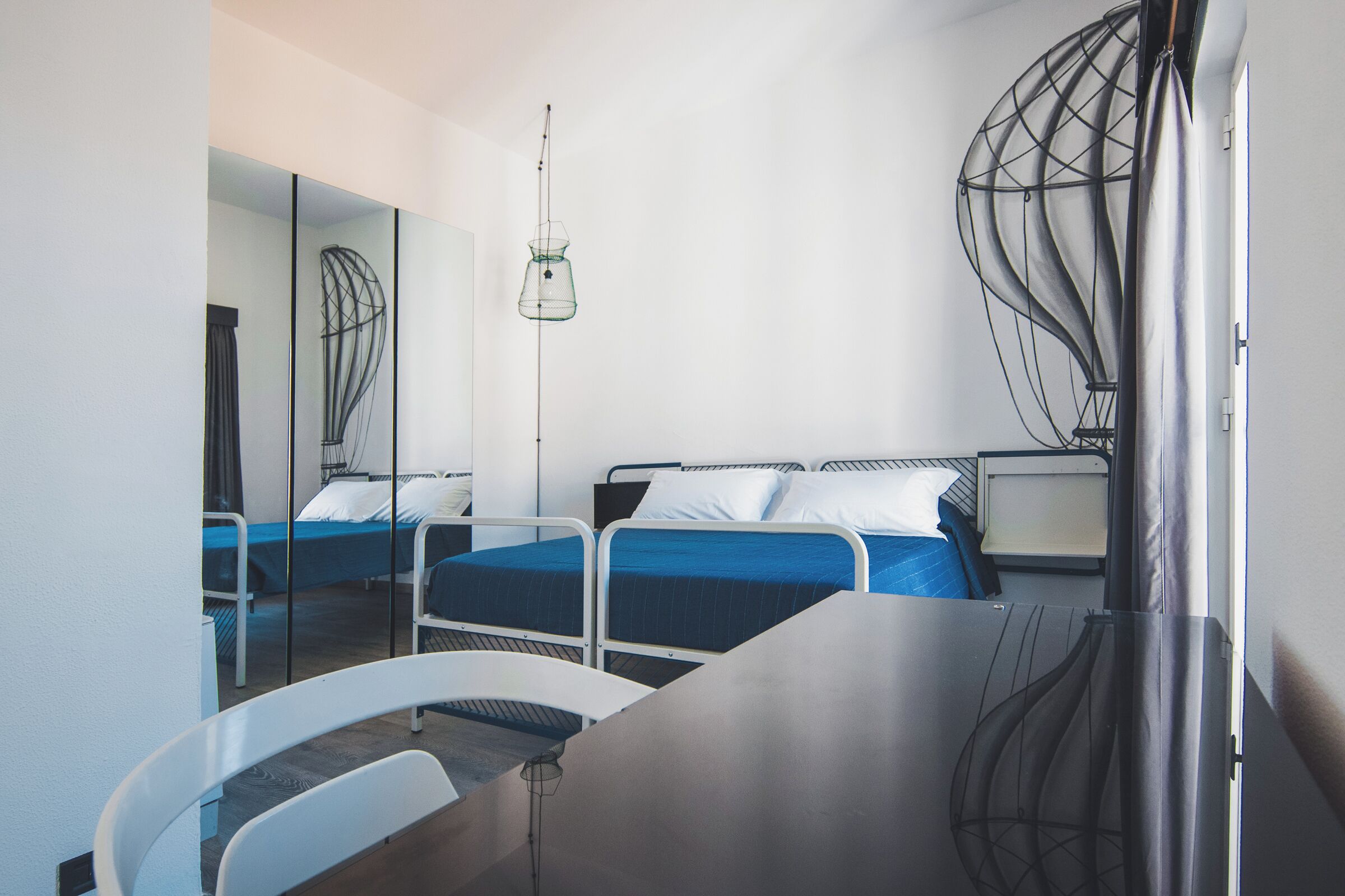 Una habitación de hotel moderna con dos camas individuales, un escritorio y una silla.