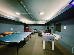A room with a ping pong table, a foosball table, and a foosball table. - Hotel Britannia (Genoa)