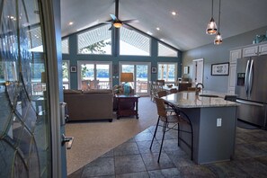 Enjoy a comfortable stay in this airy home with a spacious living area, modern kitchen, and large windows offering views of the surrounding landscape.