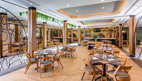 Un restaurante moderno con mobiliario de madera y un patrón de suelo tipo espiga.