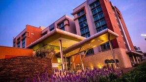 A modern hotel with a covered entrance and a large outdoor area with plants. - Southern Sun Rosebank (Johannesburg)