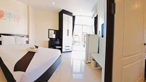 Een hotelkamer met een groot bed, een bureau, een stoel en een raam.