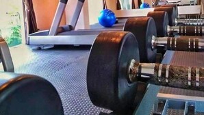 Een fitnessruimte met loopbanden, gewichtbanken en fitnessballen.