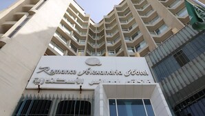 Fachada del Hotel Romane Alexandra, con un letrero llamativo y un diseño arquitectónico moderno.