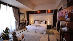 Habitación de hotel con una cama grande, un escritorio, un televisor y un frutero.