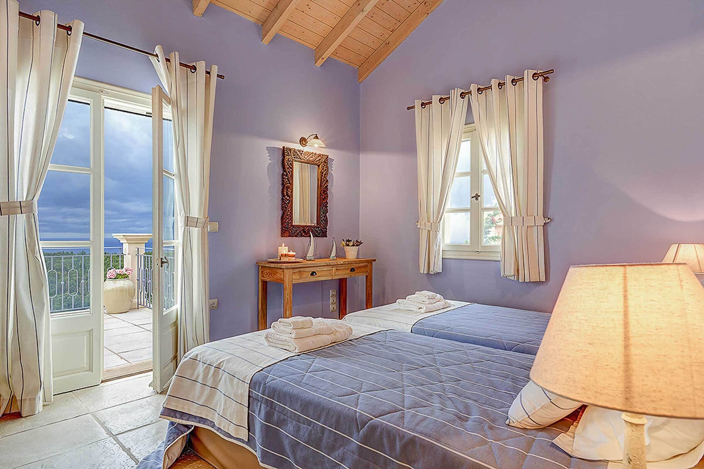 A bedroom with two beds, a nightstand, a mirror, and a window with curtains.