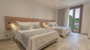 Une chambre d’hôtel avec deux lits, une tête de lit en bois, des lampes de chevet, une petite étagère et une vue sur l’extérieur grâce à une porte coulissante.
