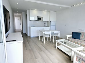Moderni huoneisto, jossa on keittiö, ruokailutila ja olohuone.