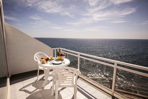 A balcony with a table set for breakfast, overlooking a body of water. - Acapulco (San Bartolomé de Tirajana)