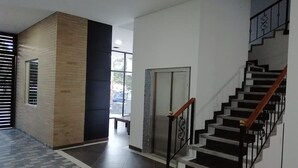 A modern interior with a staircase, a door, and a window with blinds. - Hotel Portal de los Andes (Bogotá)