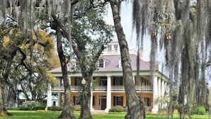 A large, two-story house with a porch and columns, surrounded by trees with Spanish moss. - The Inn At Houmas House (Darrow)