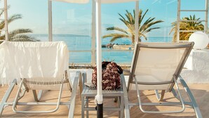 Dos sillones con vistas al mar y palmeras.