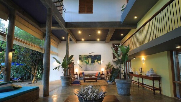 A spacious living area with a wooden coffee table, potted plants, and a sofa. - Saffron and Blue by Jetwing (Kosgoda)
