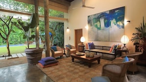 A spacious living area with a large sofa set, multiple chairs, a coffee table, and potted plants. - Saffron and Blue by Jetwing (Kosgoda)