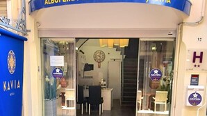 The entrance to Albufeira Beach Hotel by Kavia, featuring a blue awning, glass doors, and a green mat outside. - Albufeira Beach Hotel (Albufeira)