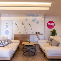 Una sala de estar moderna con dos sofás, una mesa de centro, una estantería y decoración en la pared.
