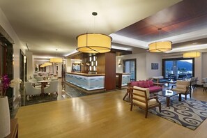 A hotel lobby with a reception desk, seating area, and a view of the mountains. - Xanadu Island (Bodrum)
