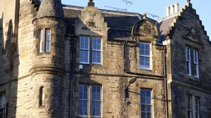 A historic stone building with multiple windows and a turret. - Grassmarket, Below Edinburgh Castle in Old Town (Edinburgh)