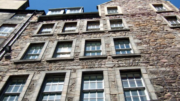 A stone building with multiple windows, some with shutters. - Advocates Close (Edinburgh)