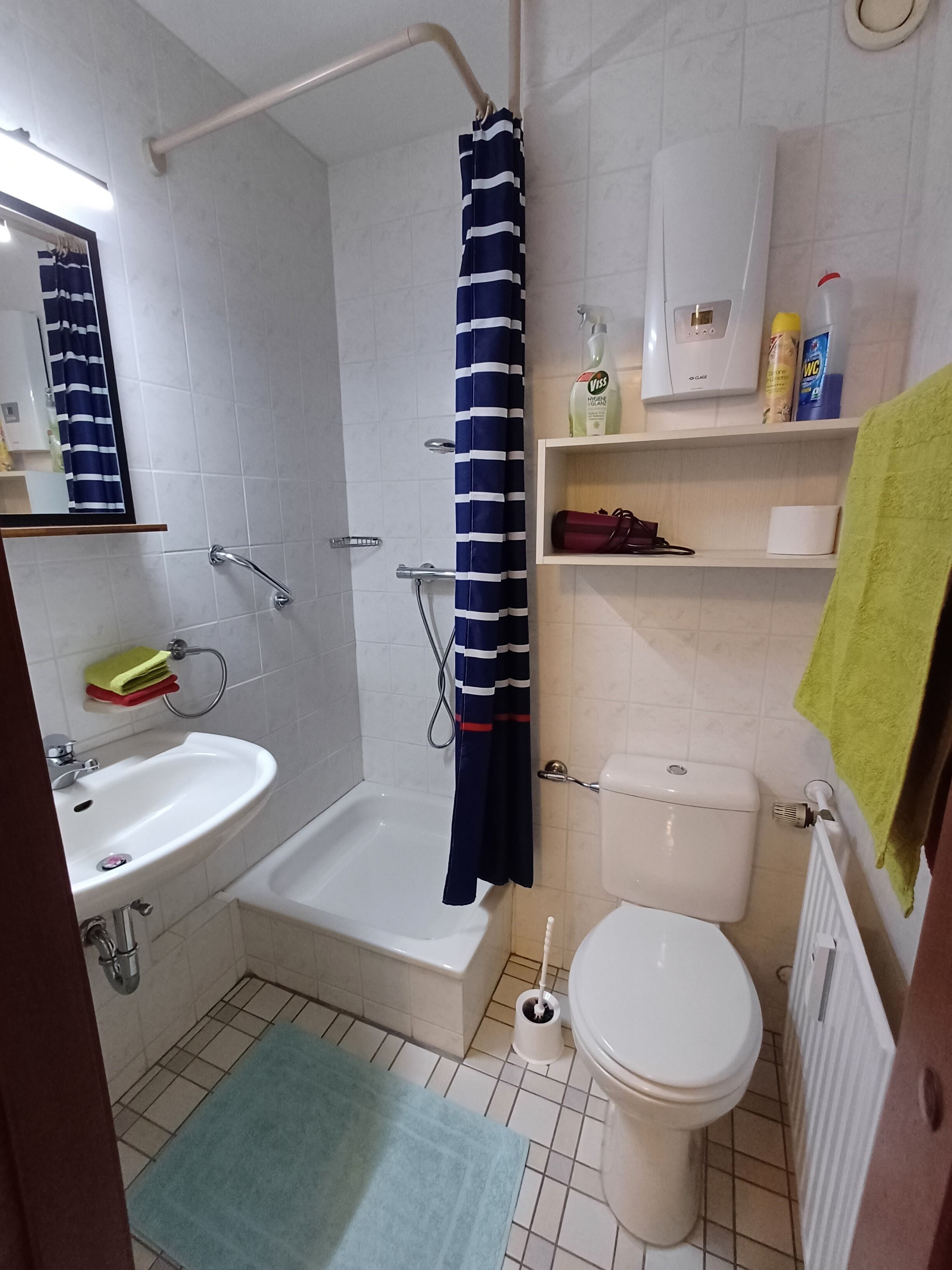 Een badkamer met een bad, een wastafel, een toilet en een douchegordijn.