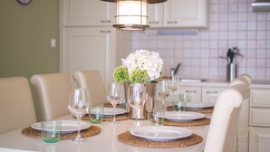 A dining table set with plates, glasses, and a centerpiece of flowers. - Stylish apartment Luce 3***** by the sea on Krk (Malinska)