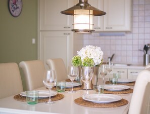 A dining table set with plates, glasses, and a centerpiece of flowers.