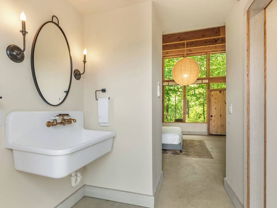 Een badkamer met een wit wastafelmeubel, een grote spiegel en twee wandlampen.