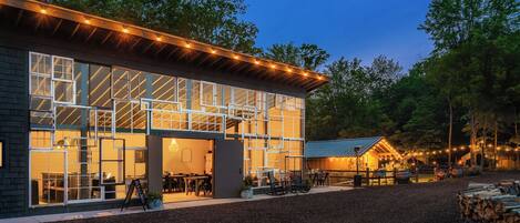 A modern building with large windows and a covered outdoor seating area.