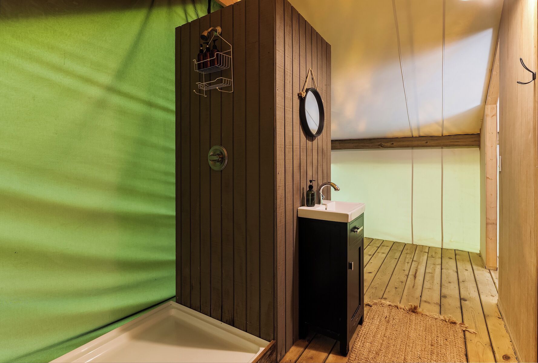 A compact bathroom with a wooden vanity, a sink, and a shower.