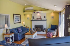 A living room with a fireplace, a sofa, a coffee table, and a television.