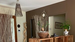 Un comedor de madera con una isla central, una lámpara colgante y un reloj fijado en la pared.