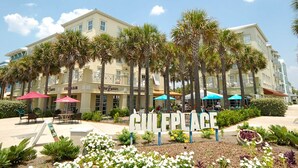 A hotel named 'GULLEPLACE' with a sign in front, surrounded by palm trees and outdoor seating areas. - Charming, Chic, Right Next to the Beach (Santa Rosa Beach)